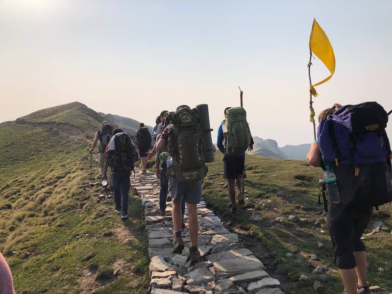 Chi Alpha students trekking a mountain ridge with packs on a mission trip